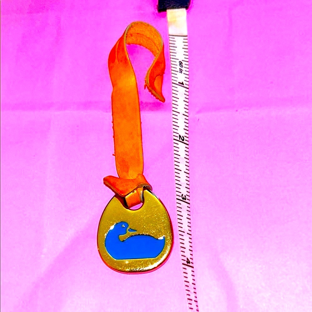 Dooney & Bourke vintage blue duck purse charm w/ tan strap.
Key/tag/fob/